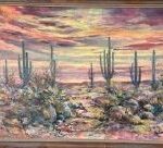 Sonoran Desert landscape with saguaro cacti and desert scrub beneath a colorful sunset sky of pink, purple, and gold.